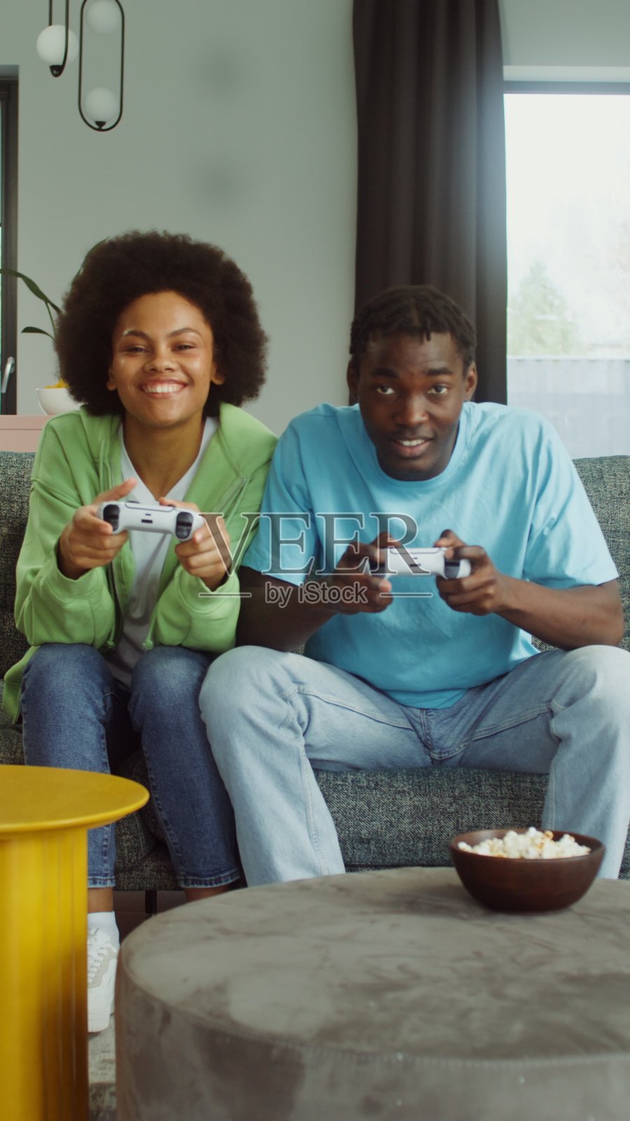 一对情侣在玩电子游戏，玩得很开心。照片摄影图片