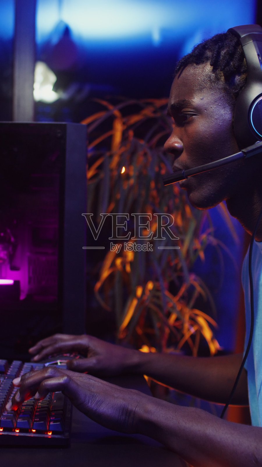 戴着耳机和麦克风玩电脑游戏的男人照片摄影图片