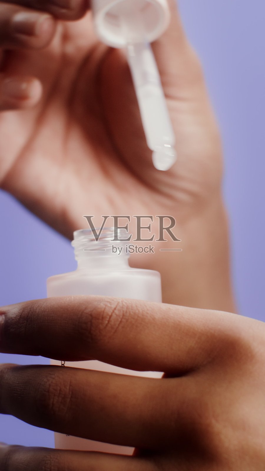 一位年轻女子正在从“Care”品牌中吸取保湿精华液。照片摄影图片