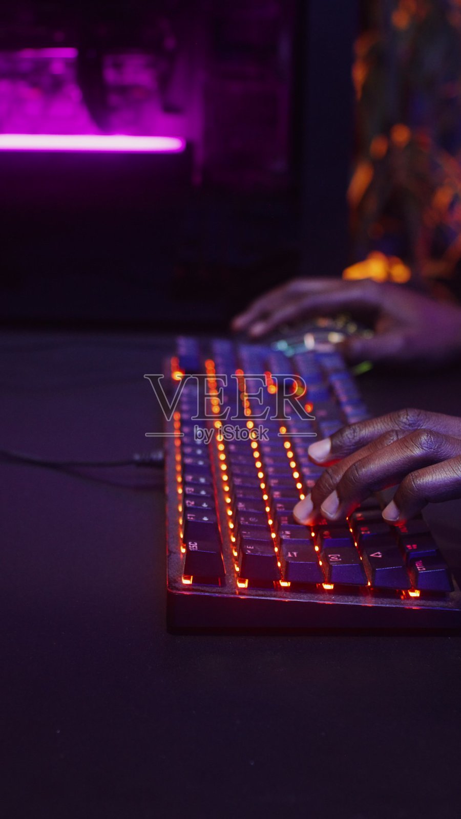 一名男子在使用键盘玩电脑游戏照片摄影图片