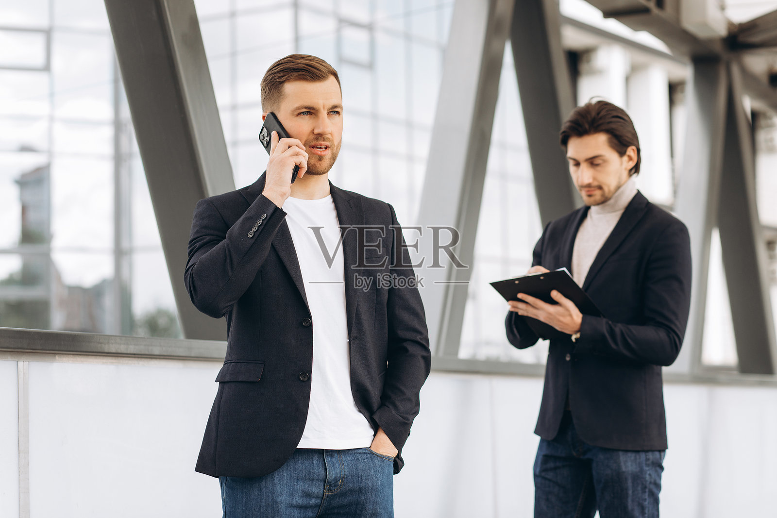 商务专业人士在现代办公室环境中通过智能手机交流、写笔记并协作工作照片摄影图片