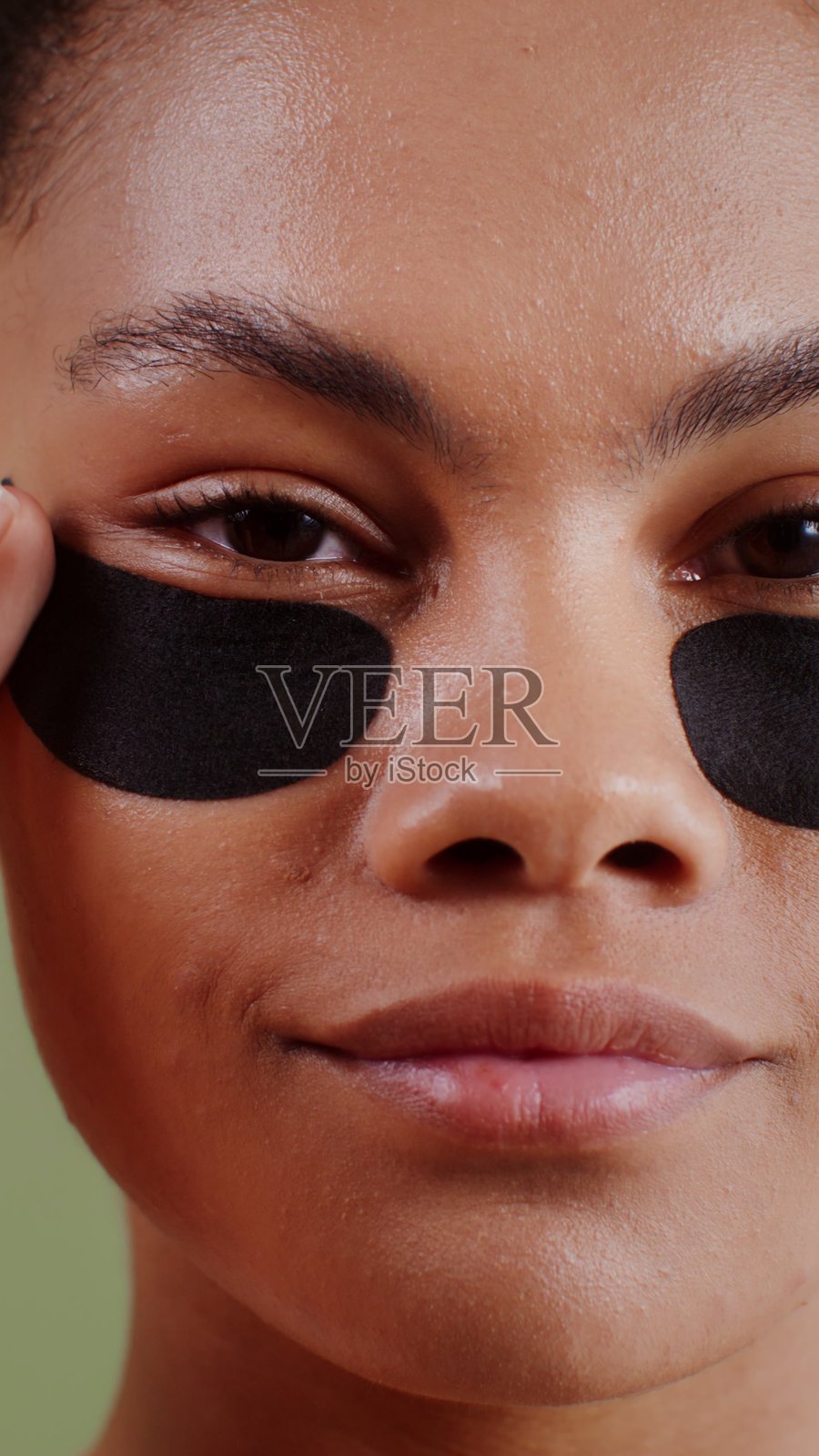 年轻的非裔美国女性，眼下贴着眼贴，呵护肌肤。照片摄影图片