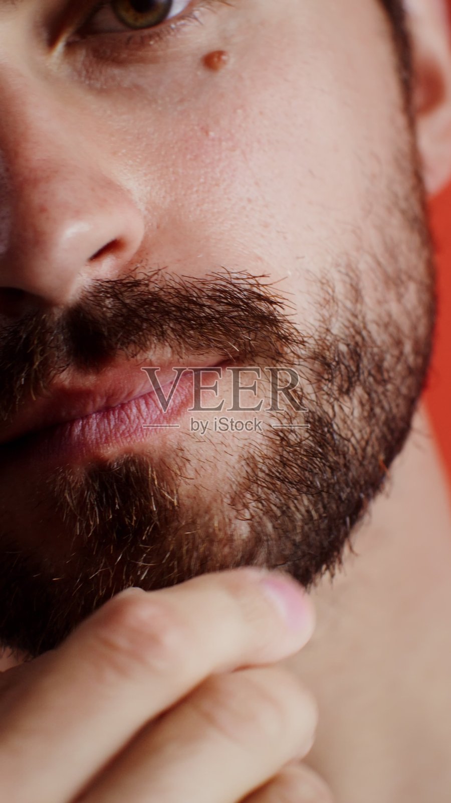 年轻男子摸着胡须，若有所思照片摄影图片