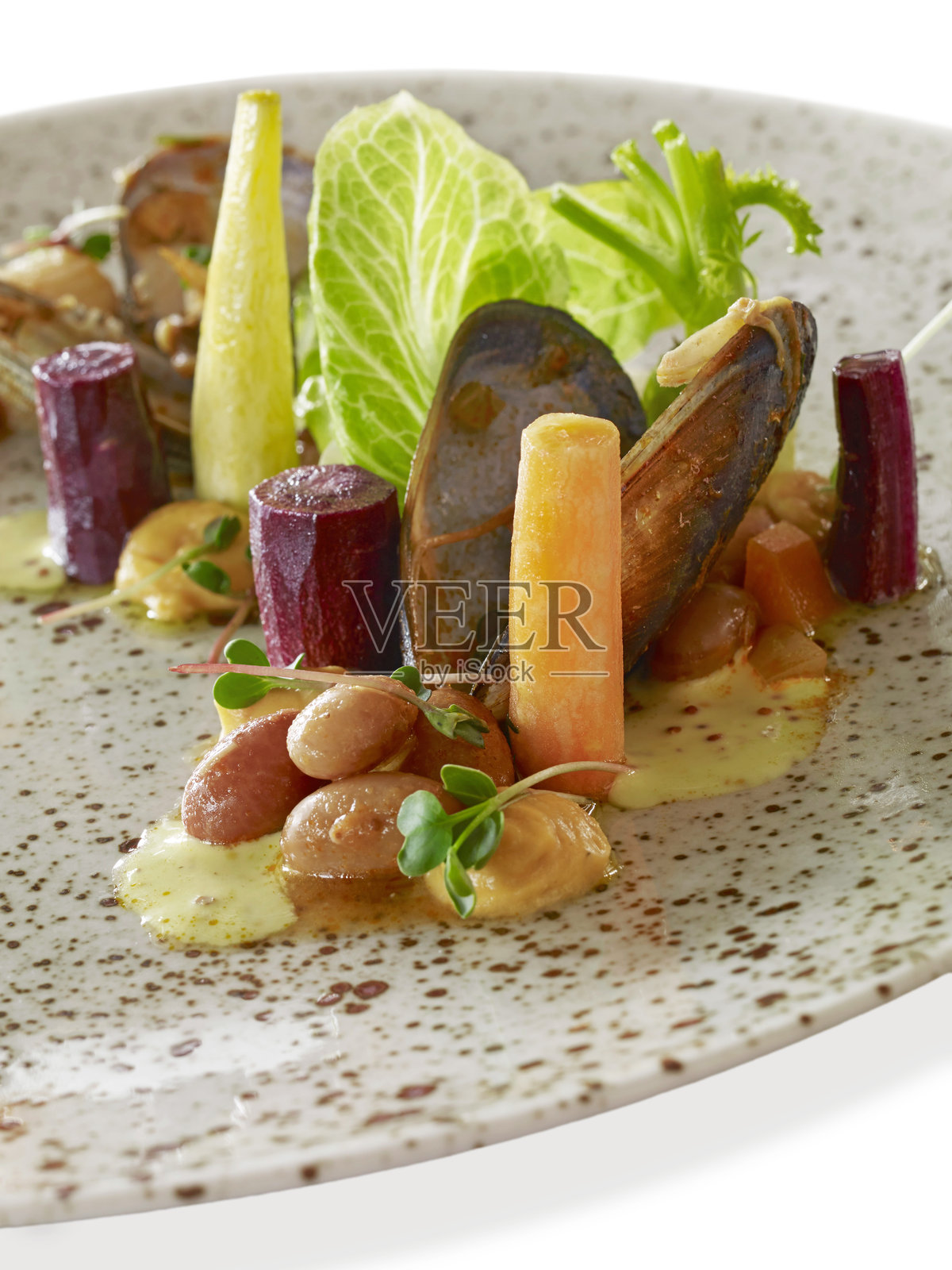 白底上摆盘的、配有蔬菜的美味贻贝和海鲜菜肴照片摄影图片