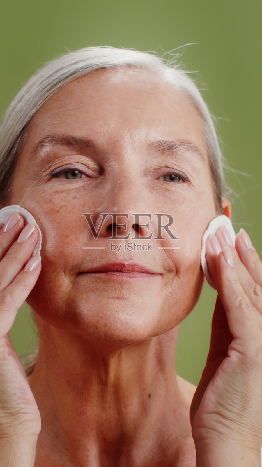 一位老年女性使用化妆棉护理脸部照片摄影图片