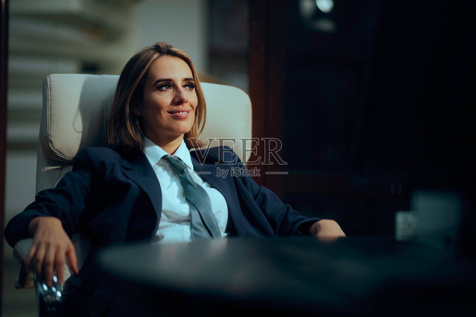 女商人坐在经理椅上，掌管公司照片摄影图片