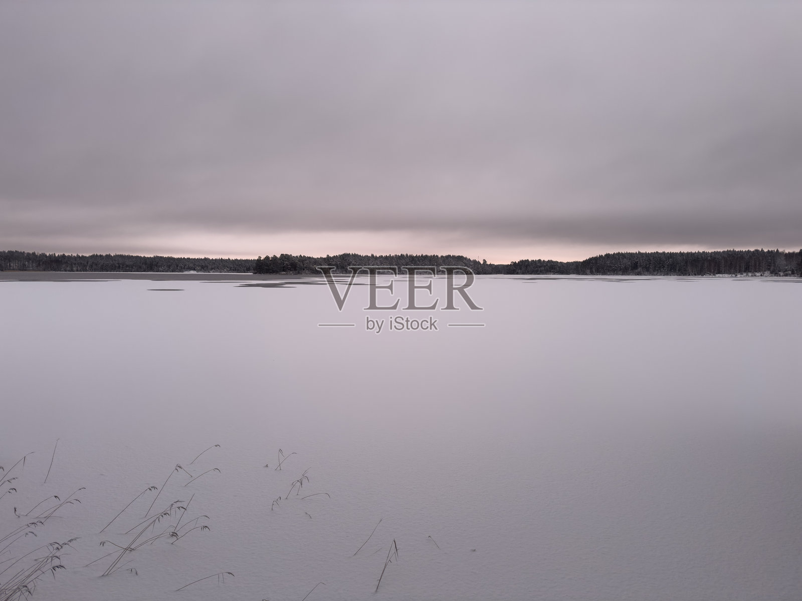 冬日瑞典，日落时分的冰封湖面。照片摄影图片