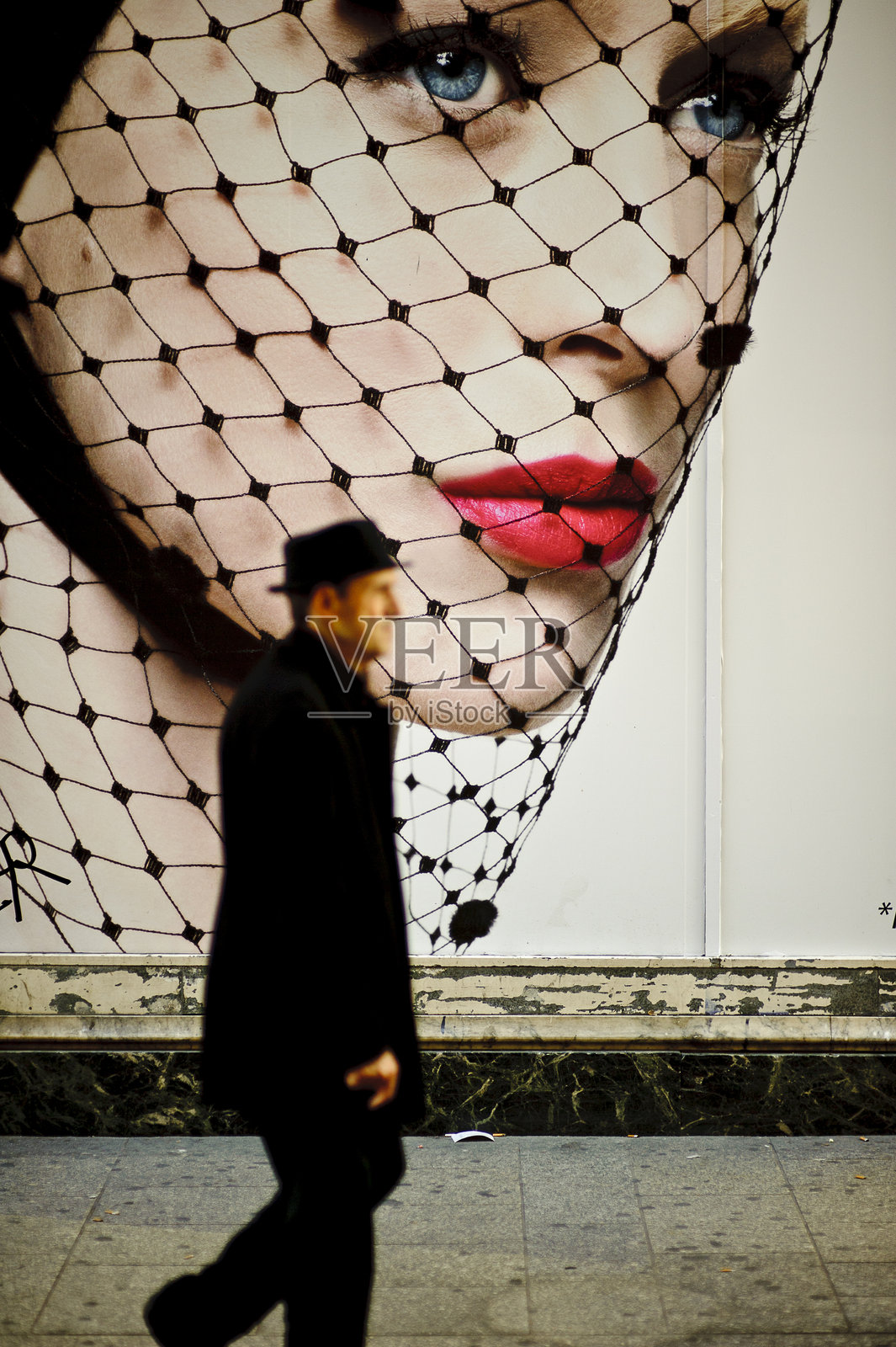 男人走在海报前照片摄影图片