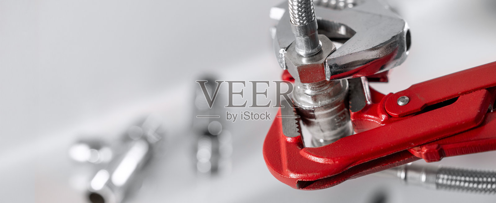 水管工正在拧紧水管接头。管道服务与维修。带复制空间的横幅。照片摄影图片