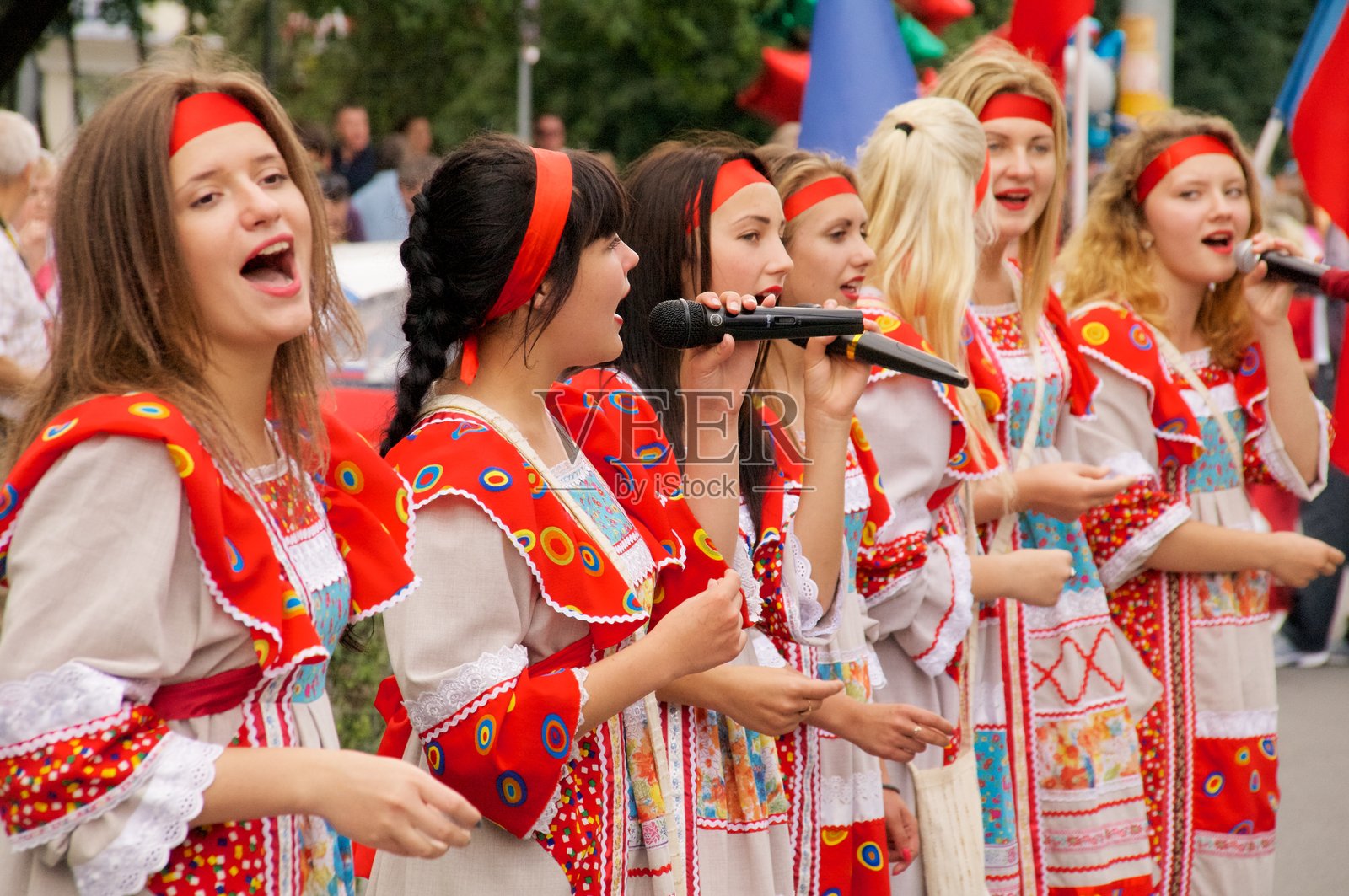 穿着俄罗斯民族服装的女孩们在街上歌唱照片摄影图片