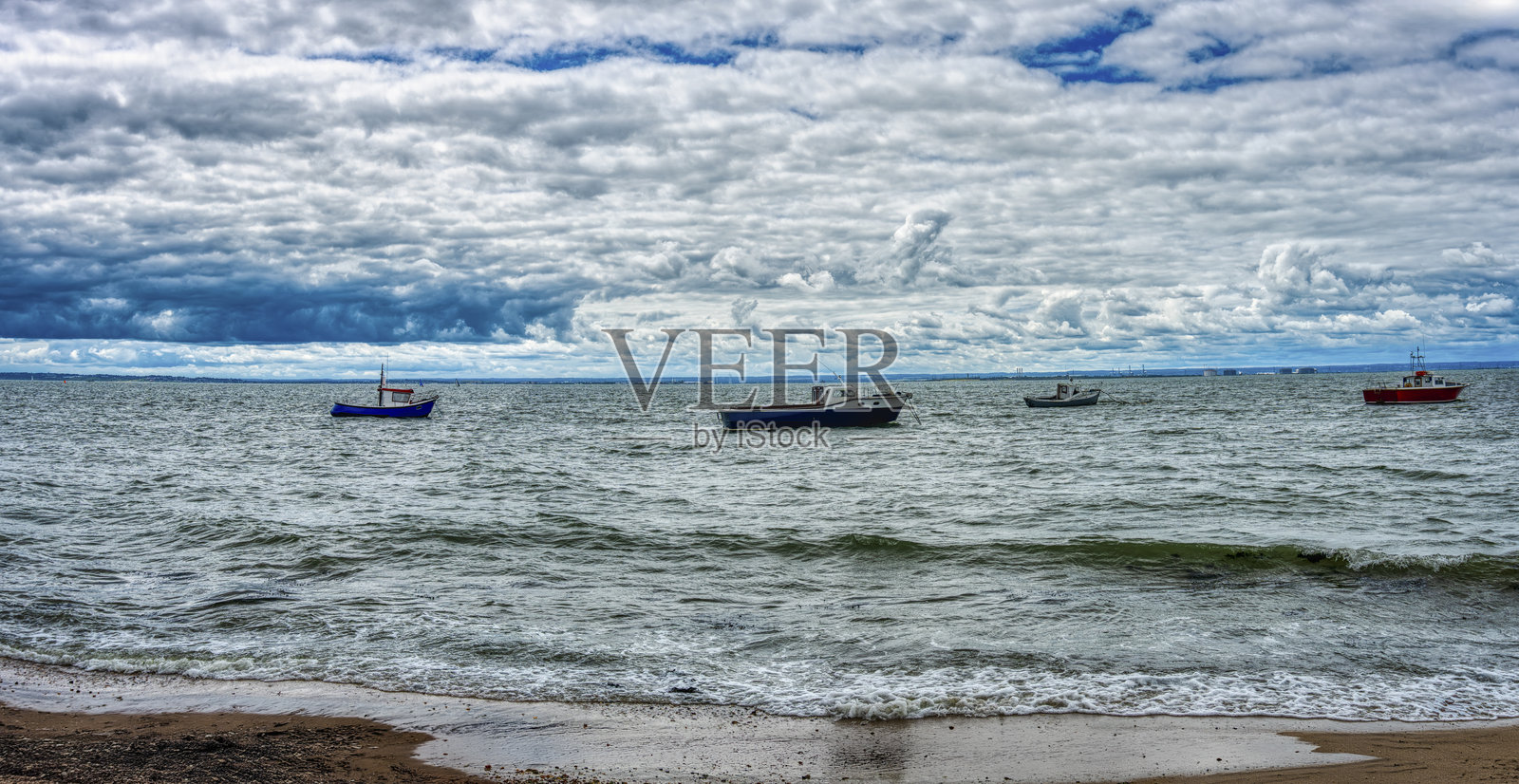 英国英格兰贝德福德海岸停泊的渔船，阴沉海岸背景下的海滨照片摄影图片