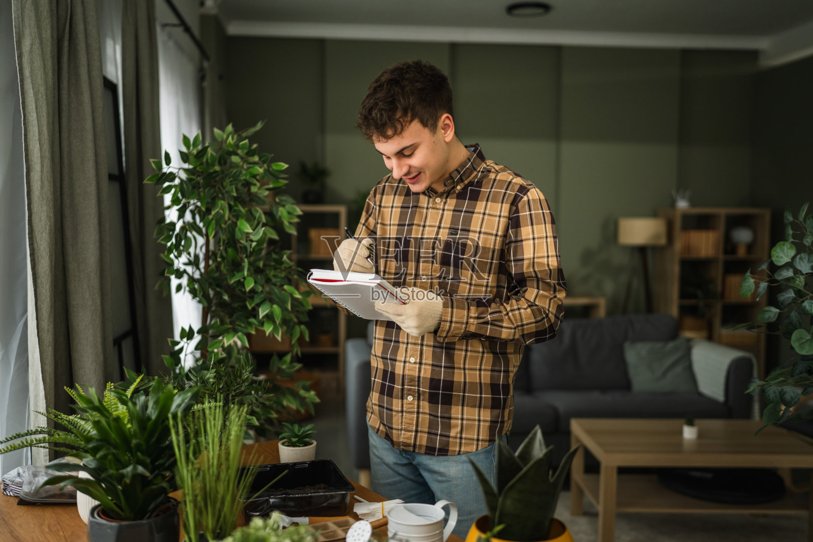 一位微笑的男士正在种植植物并做笔记照片摄影图片
