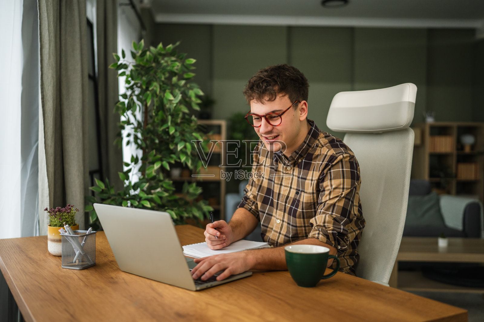 年轻男子在家中办公室使用笔记本电脑工作照片摄影图片