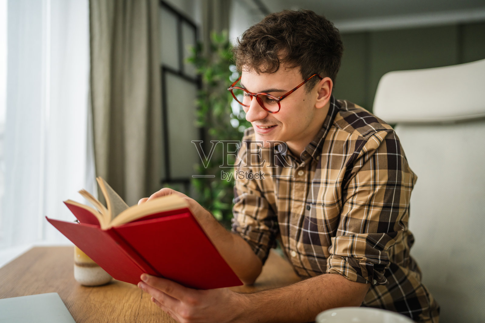 年轻男子在家学习，阅读书籍照片摄影图片