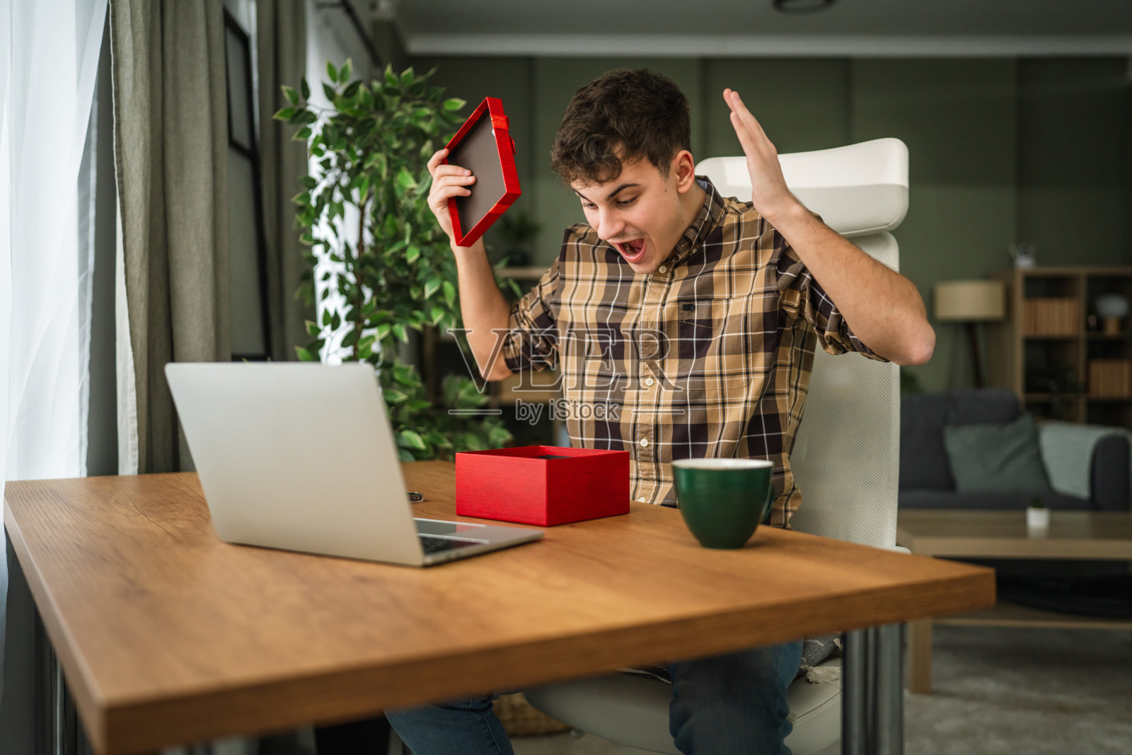 年轻人惊喜兴奋地打开礼物盒照片摄影图片