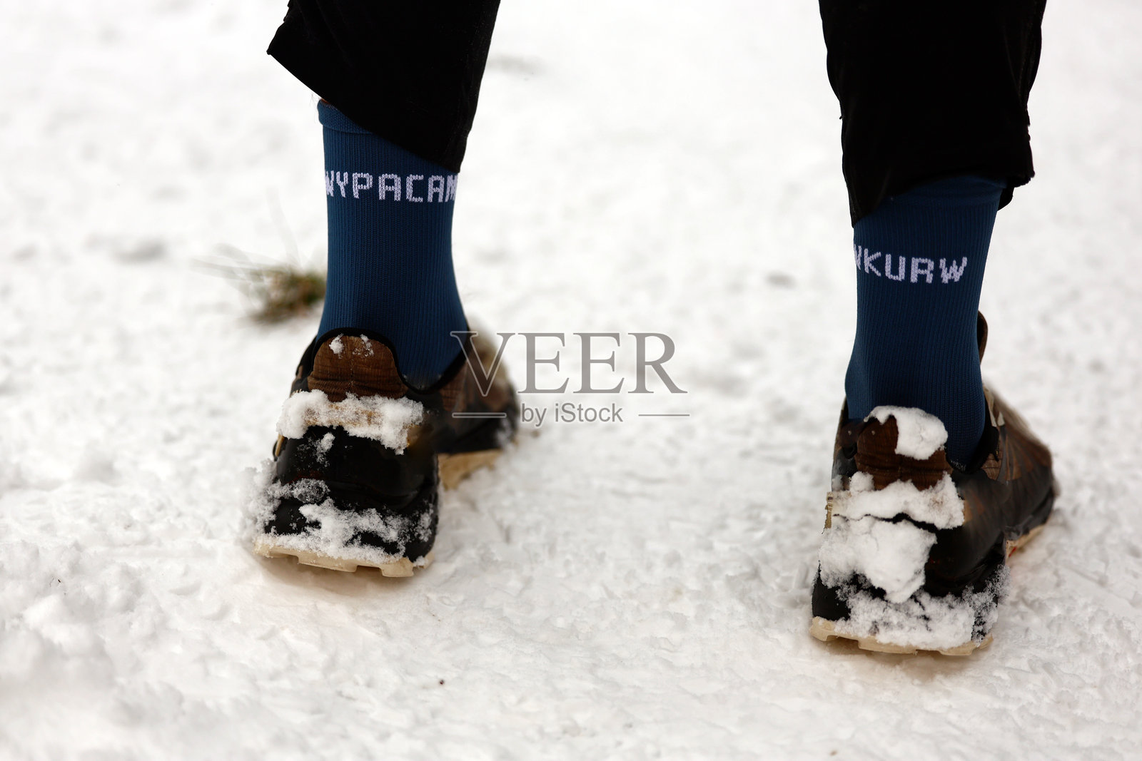 冬日里，覆盖着雪的鞋子和印有幽默文字的蓝色袜子照片摄影图片