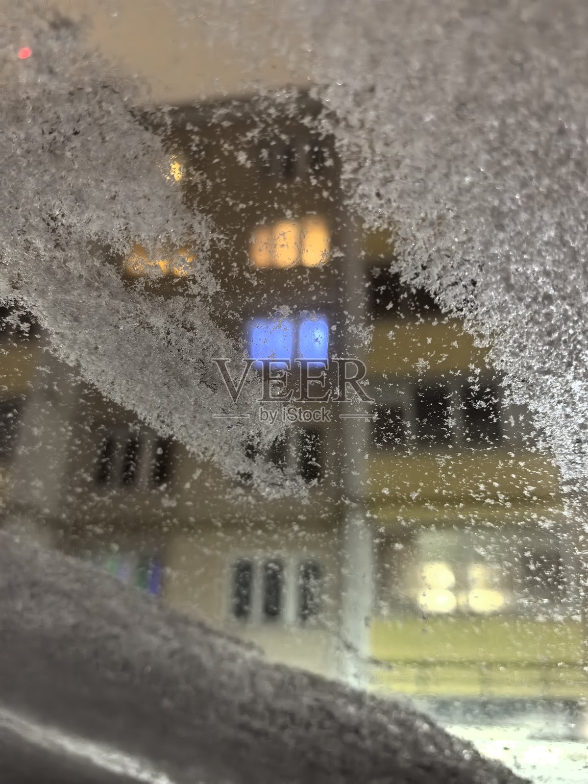 透过雪覆盖的窗户看到的景象，窗户上的雪，冬天的城市，冬季城市景观，窗户上的霜，城市里的冬天，雪景街道的美丽照片照片摄影图片