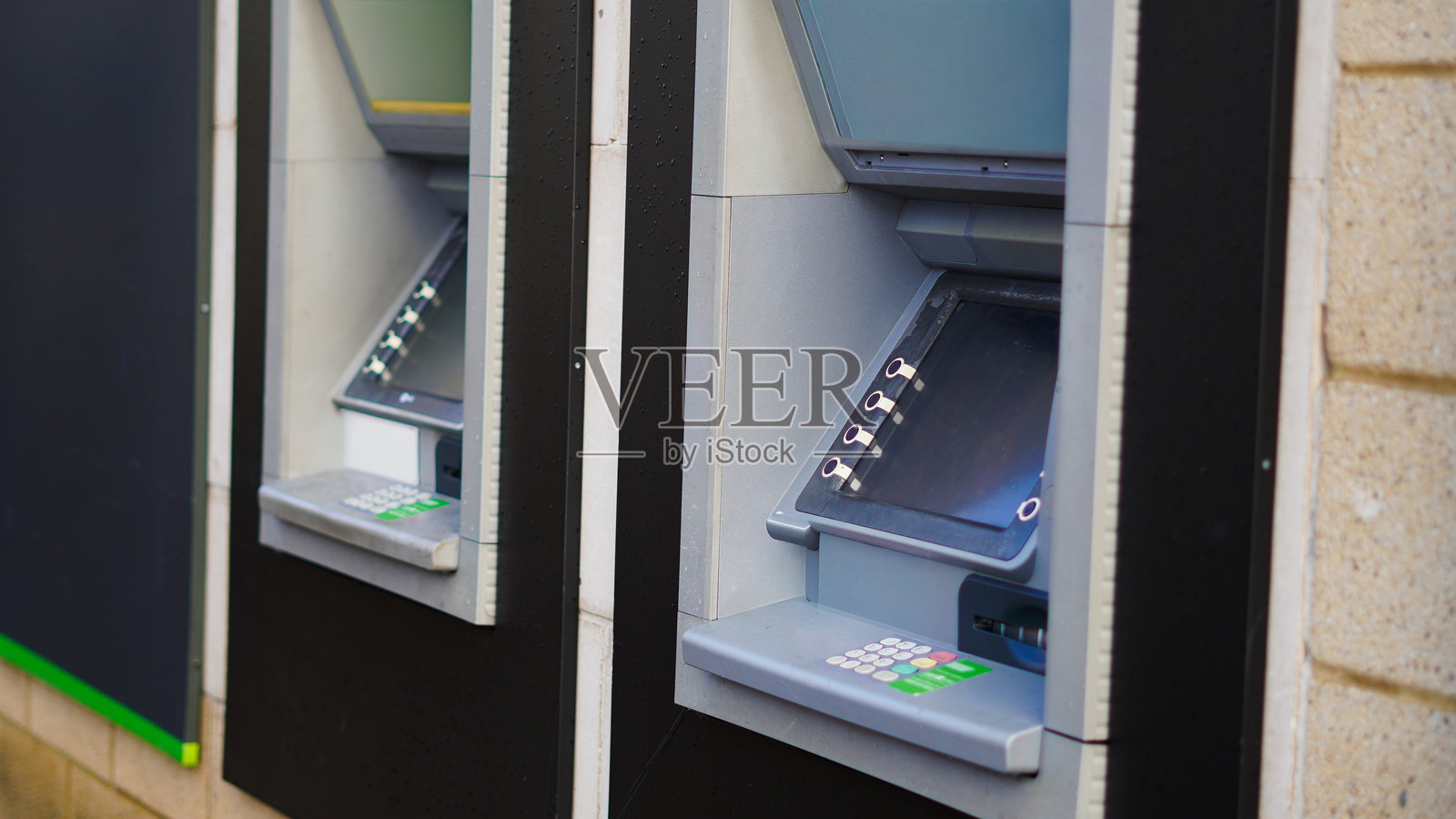 两台设计时尚的现代自动取款机，背景为纹理墙照片摄影图片