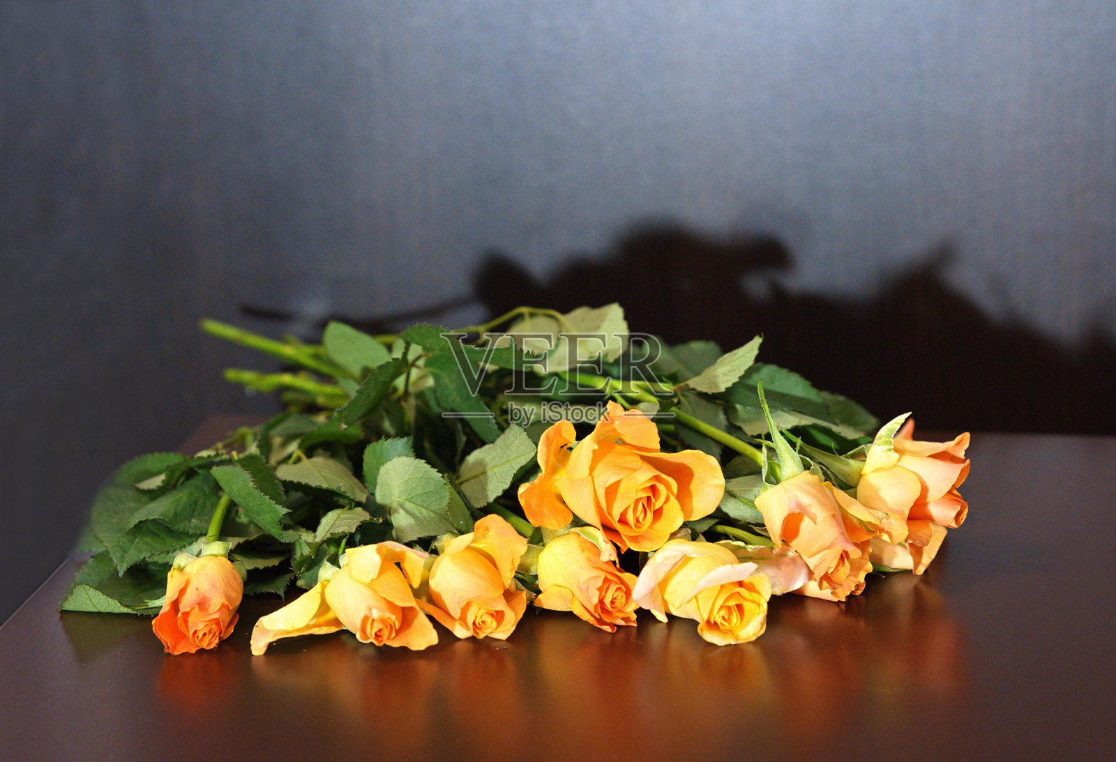 桌子上放着一束桃粉色玫瑰花束。照片摄影图片