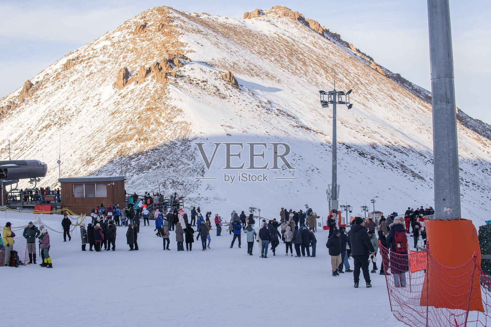 大批人群在山区排队等待乘坐缆车。旅游旺季，游客在繁忙的缆车站排着长队，代表了大众旅游、旅游需求、户外休闲和热门山区目的地。照片摄影图片