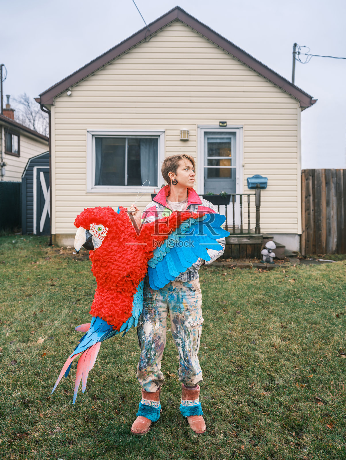 年轻的女艺术家在她家门前展示她制作的纸浆雕塑鸟照片摄影图片