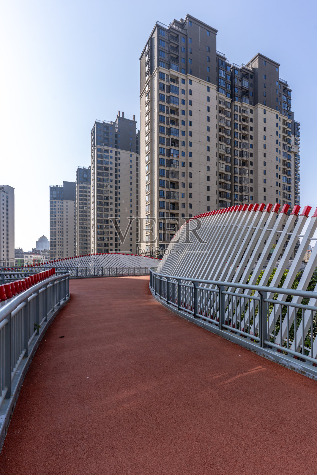 红色的沥青路和旁边的城市建筑照片摄影图片