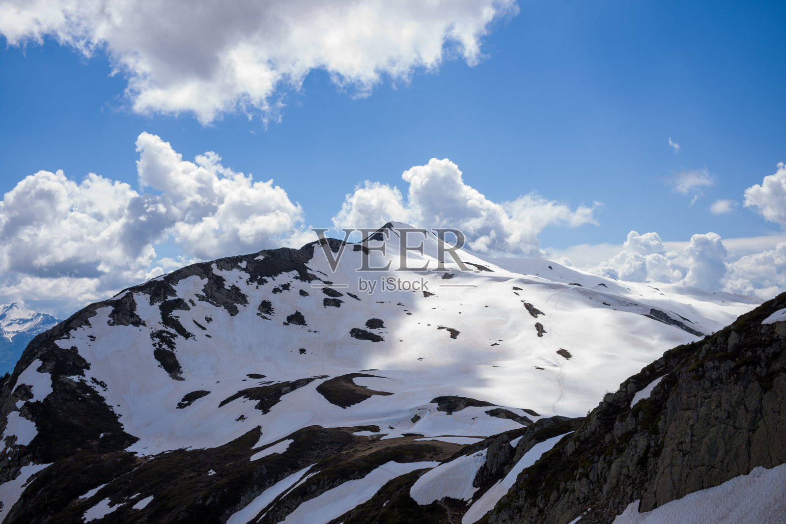 雪山山脊在戏剧性的云层下照片摄影图片