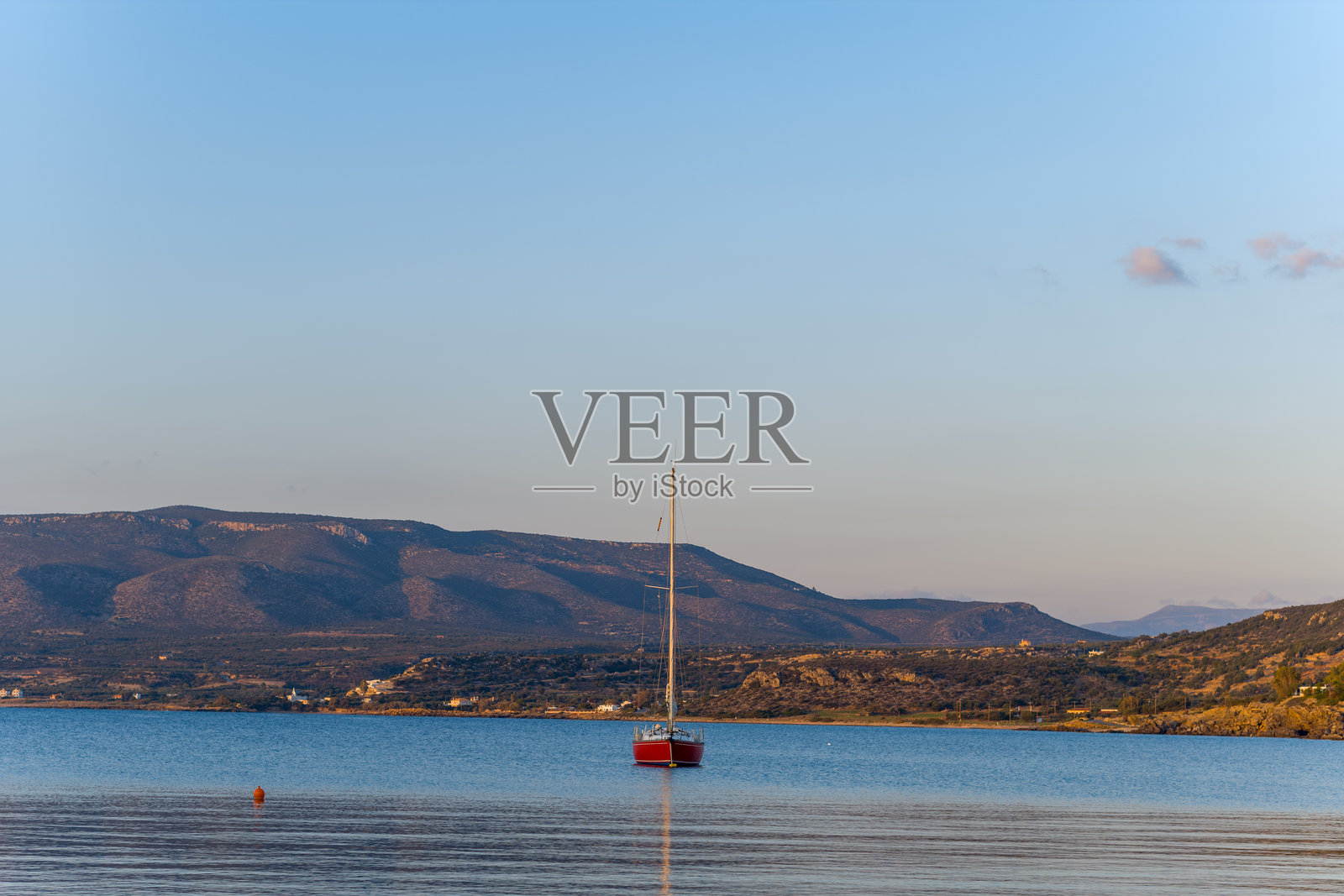 红色的帆船静静地停泊在阿尔汉格洛斯平静的海面上照片摄影图片