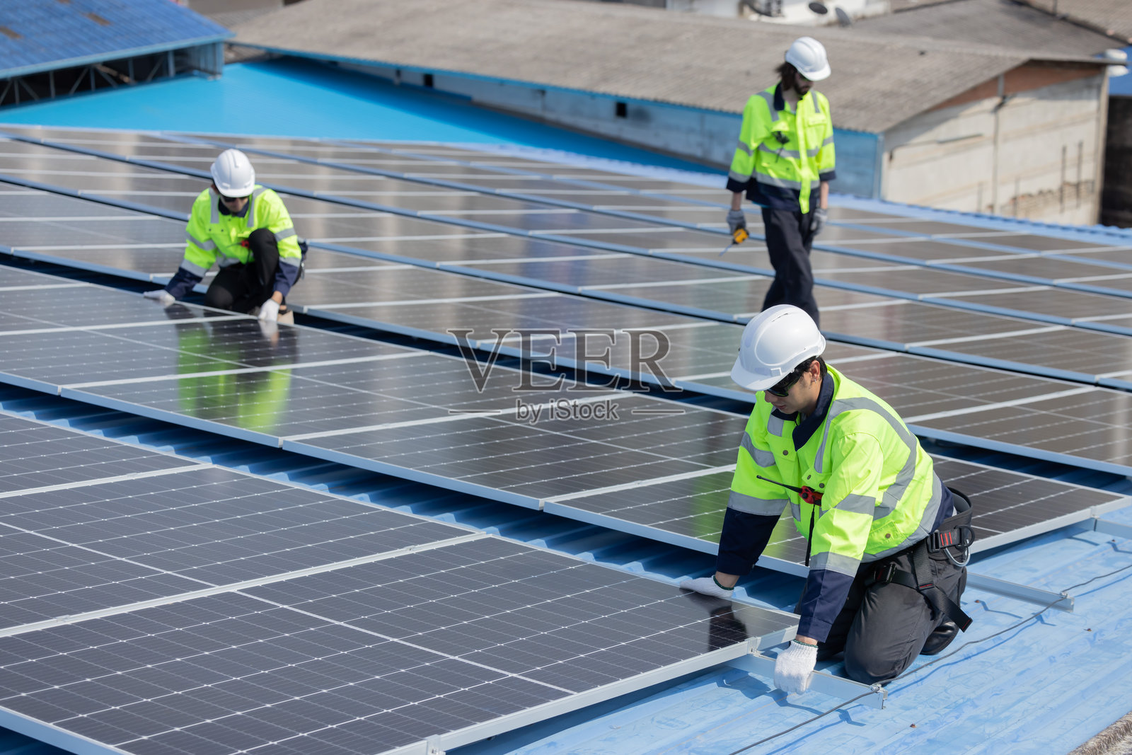 工程师在工厂屋顶维修太阳能电池板照片摄影图片