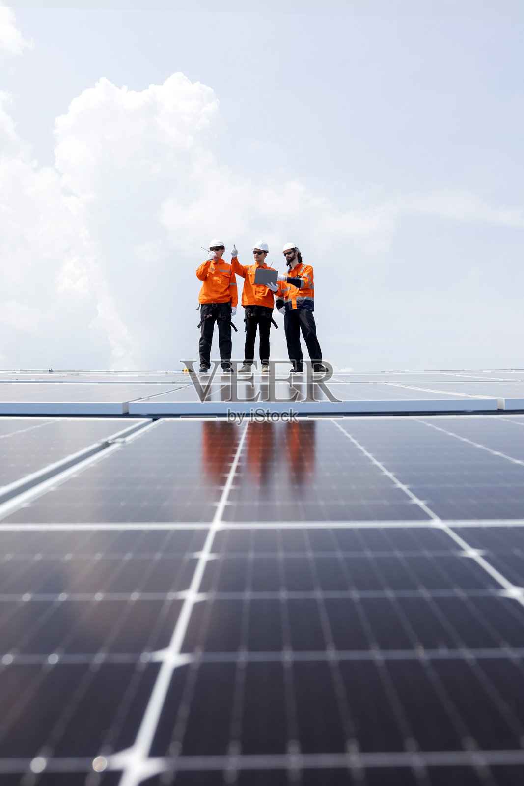 工程师在屋顶检查太阳能电池板的垂直视图照片摄影图片