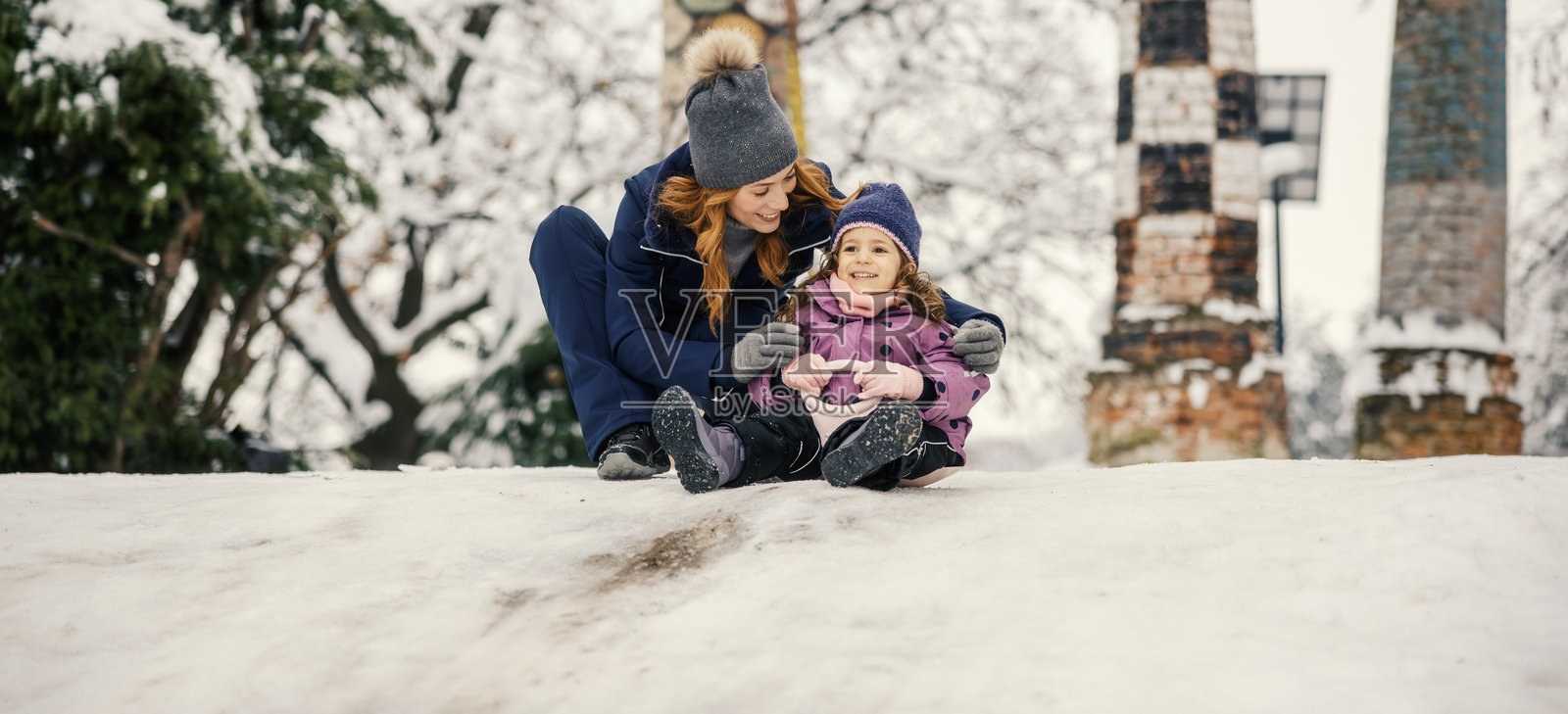 母女俩一起玩雪橇，享受冬日乐趣照片摄影图片