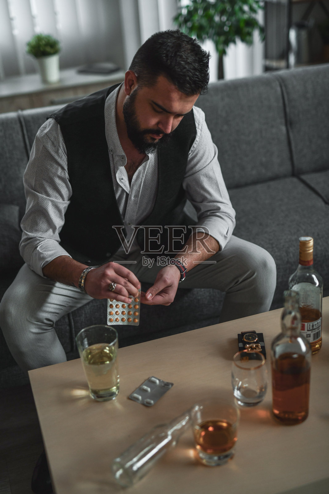 男人在家坐在桌边，桌上放着药物照片摄影图片