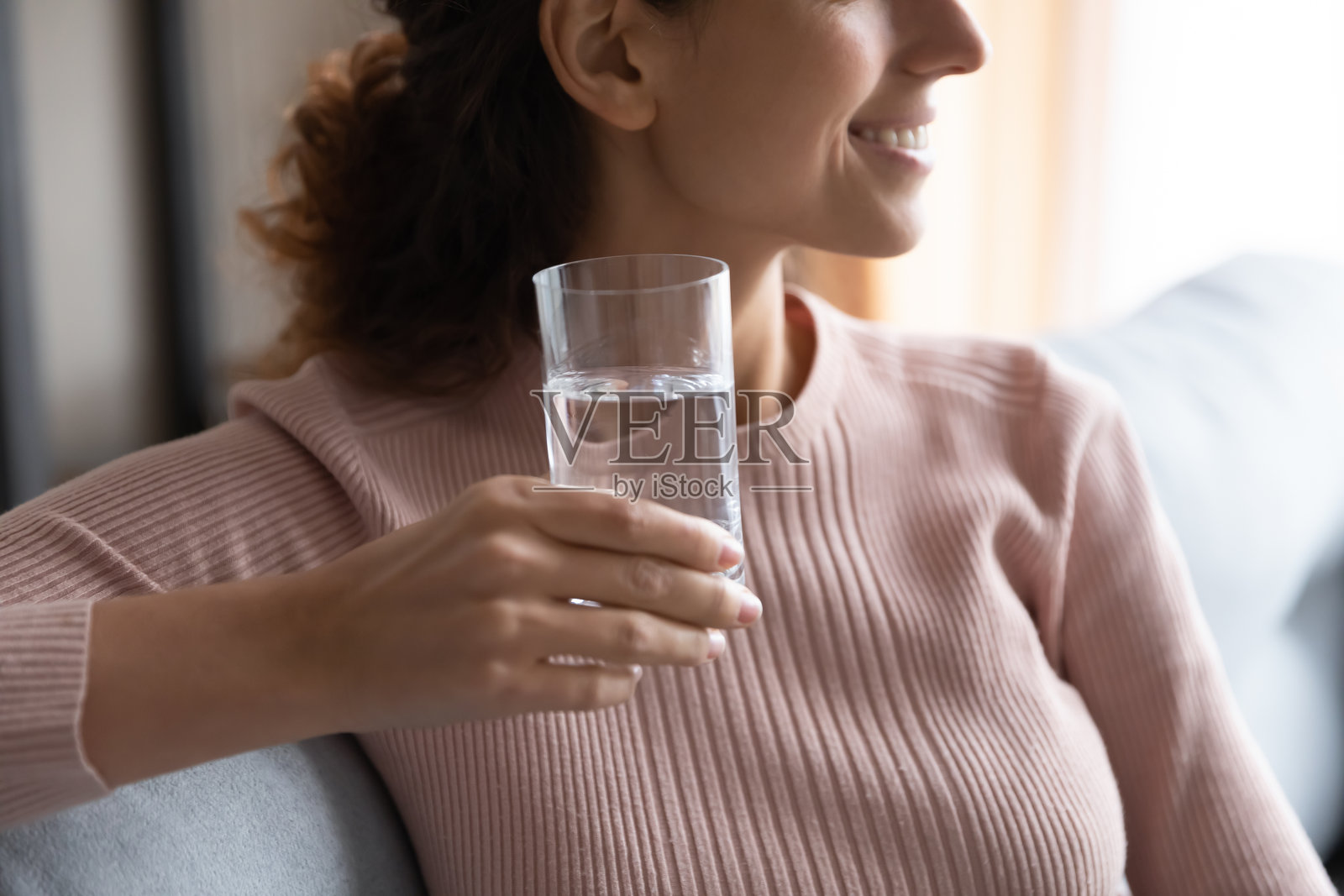 特写镜头：一位梦幻般的年轻女子手持一杯纯净水照片摄影图片