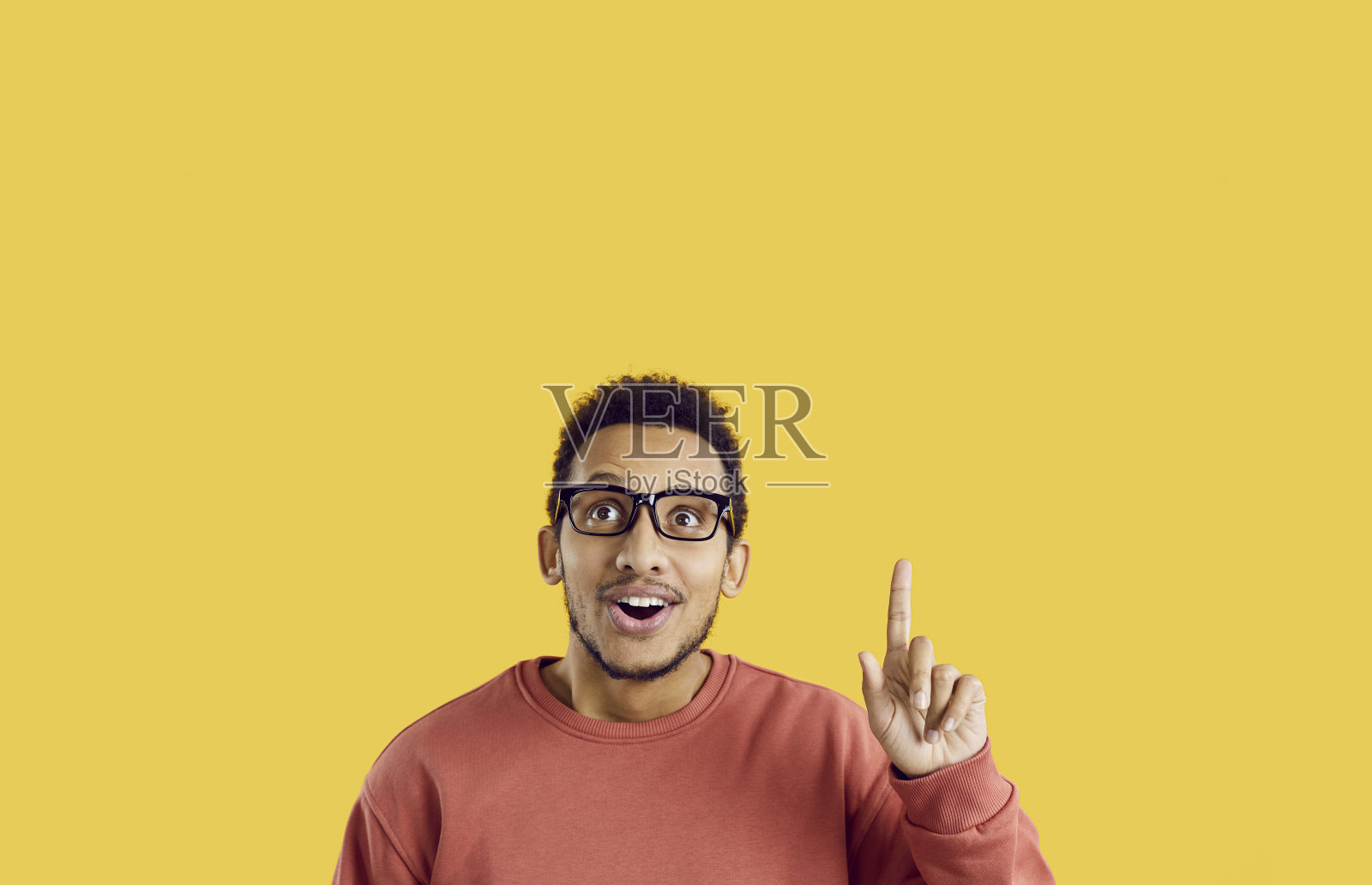 一位情绪化的深肤色男子肖像，他有一个绝妙的主意，找到了灵感或问题的解决方案。照片摄影图片