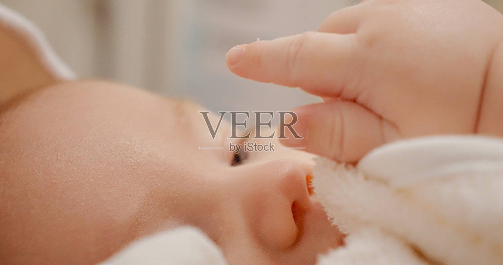 活跃的新生儿通过触摸享受和探索自己的身体照片摄影图片