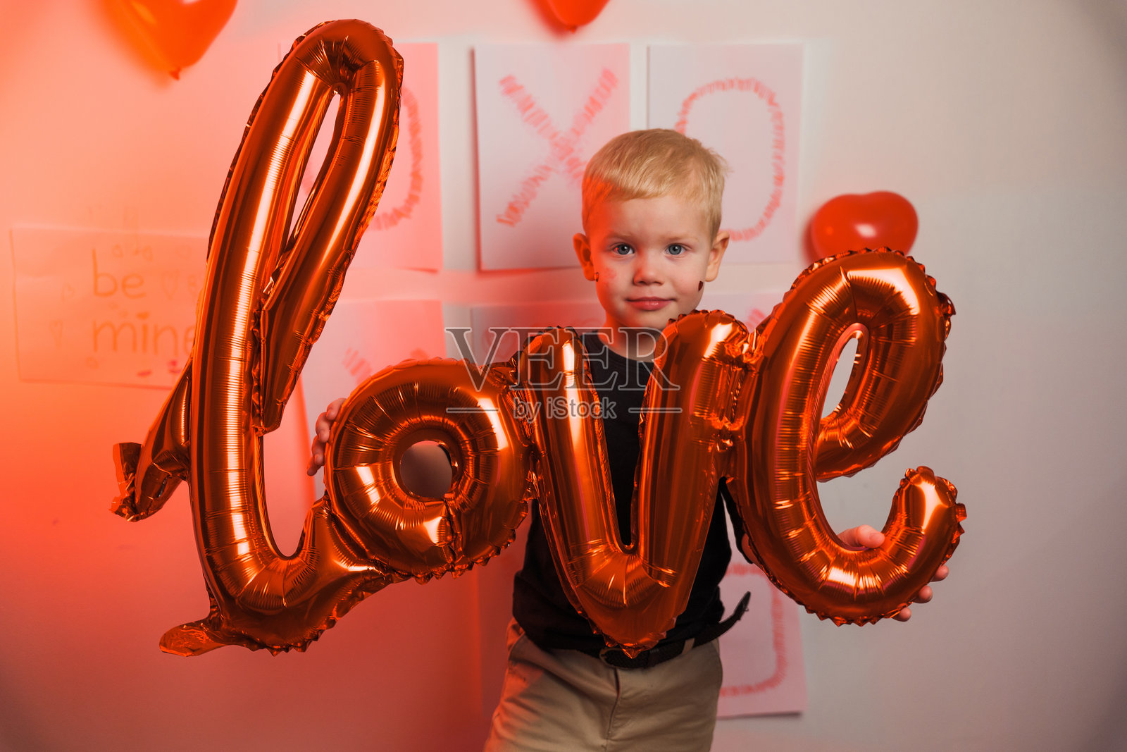 孩子在装饰的房间里拿着一个大大的爱心气球，庆祝特殊活动照片摄影图片