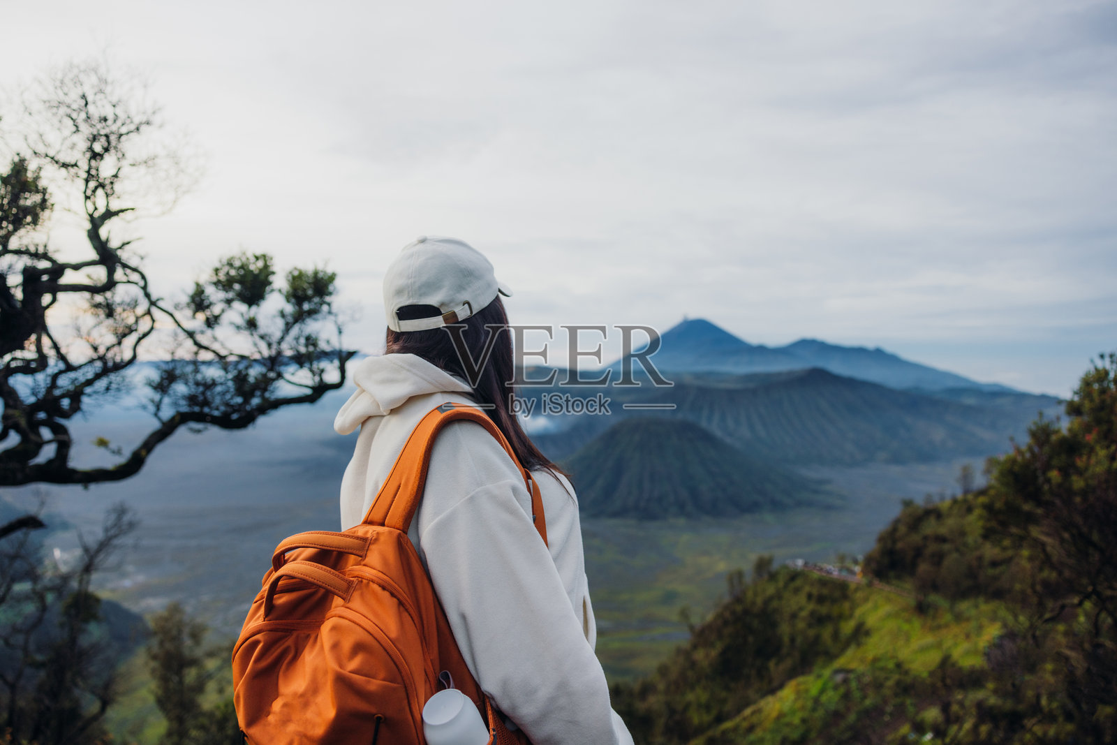 日出时分，一名女子在印度尼西亚欣赏婆罗摩苏门火山壮丽的景色照片摄影图片