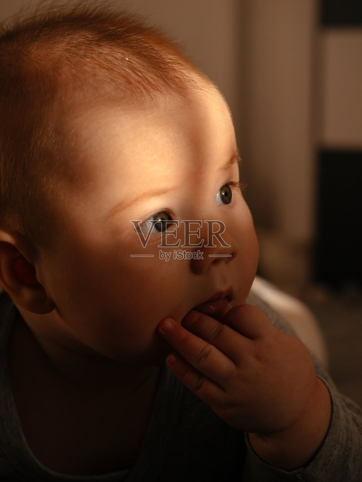 温馨灯光下的婴儿卧室，捕捉天真与好奇照片摄影图片