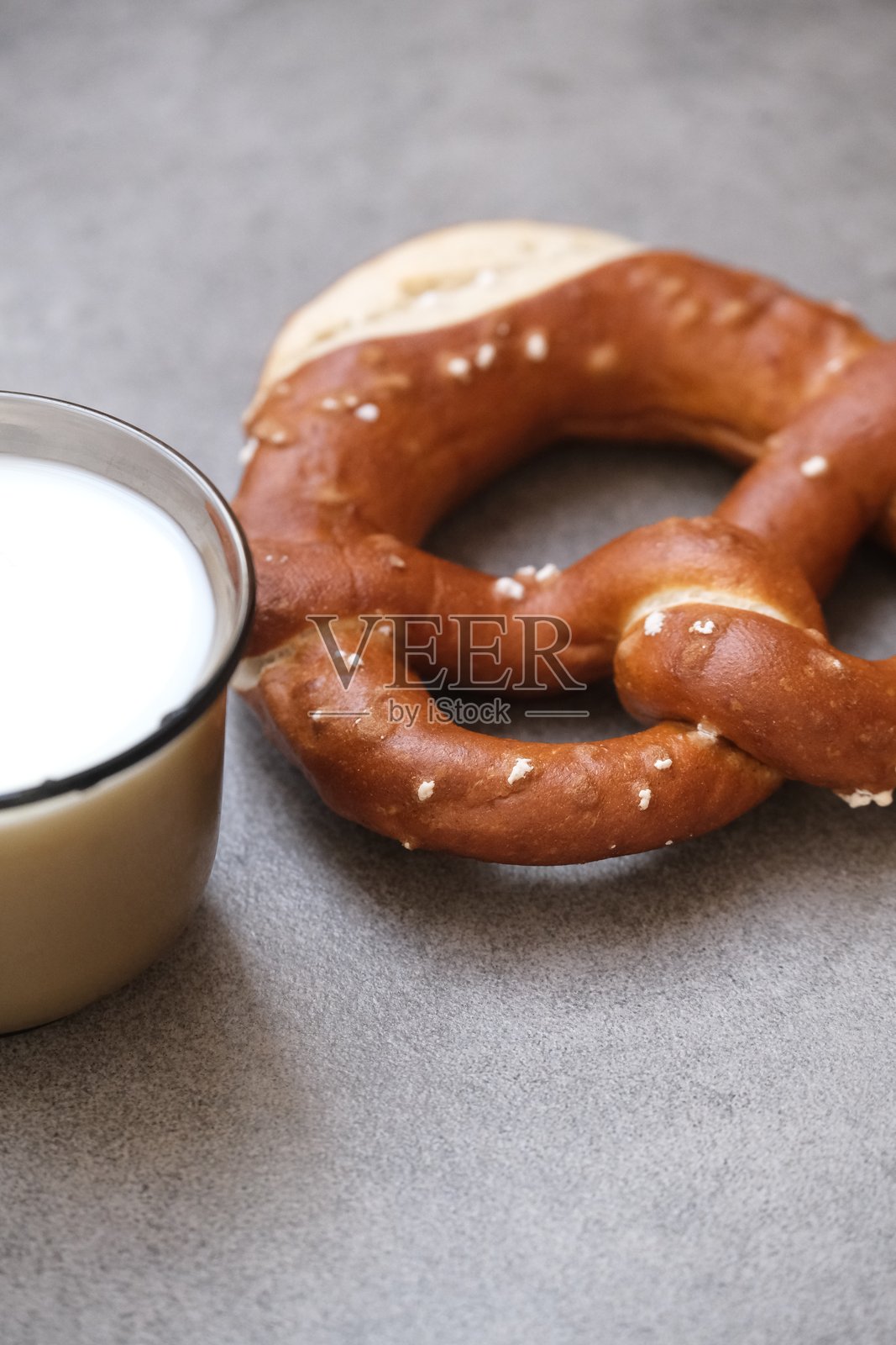 美味的传统巴伐利亚椒盐卷饼，外皮呈棕色并带有咸味。德国椒盐卷饼配一杯牛奶。慕尼黑啤酒节上的美食。照片摄影图片