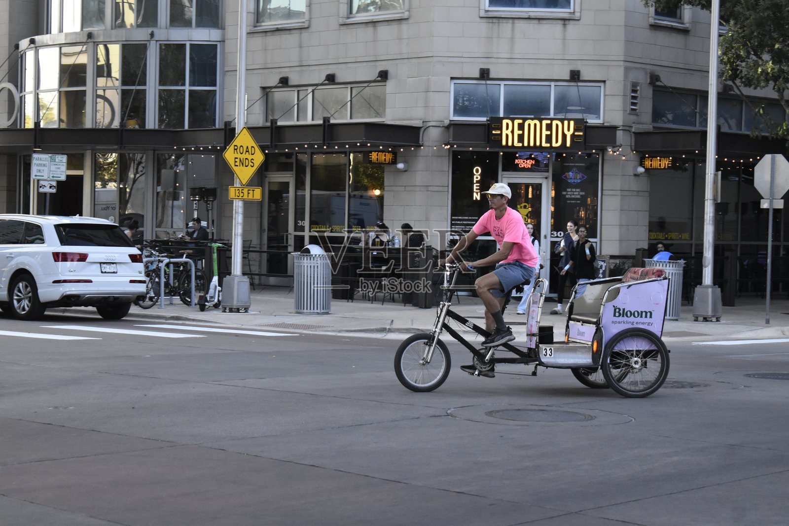 一位中年男子在奥斯汀金融区中心的Remedy餐厅附近骑着一辆马车式自行车。照片摄影图片