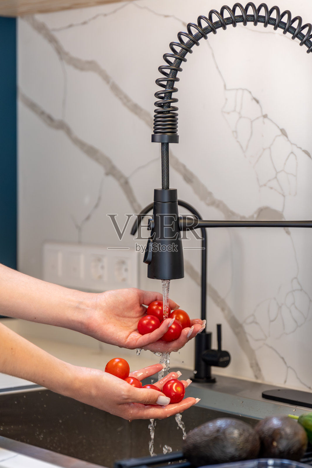 女性双手在水龙头下清洗樱桃番茄，干净的准备工作。照片摄影图片