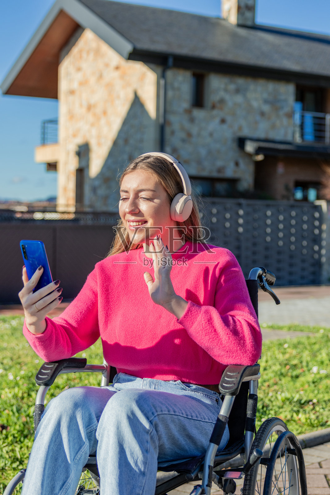 坐轮椅的年轻女子正用智能手机进行视频通话照片摄影图片