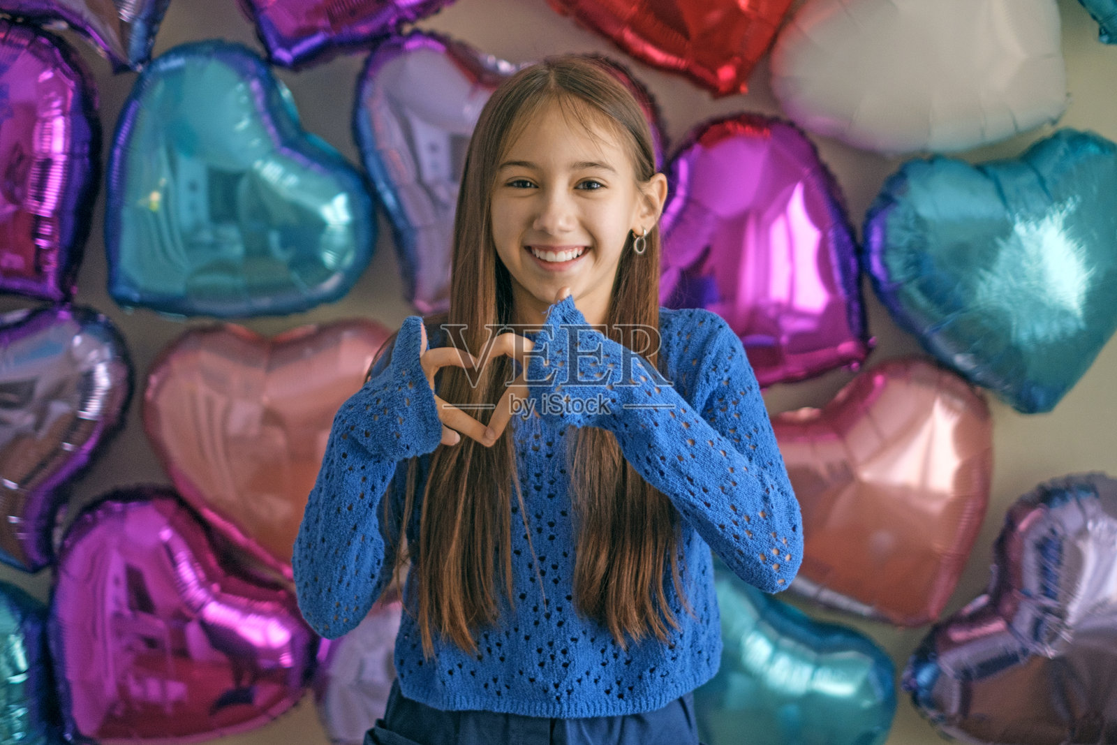 一位少女用手指比心，在情人节展现爱意手势照片摄影图片