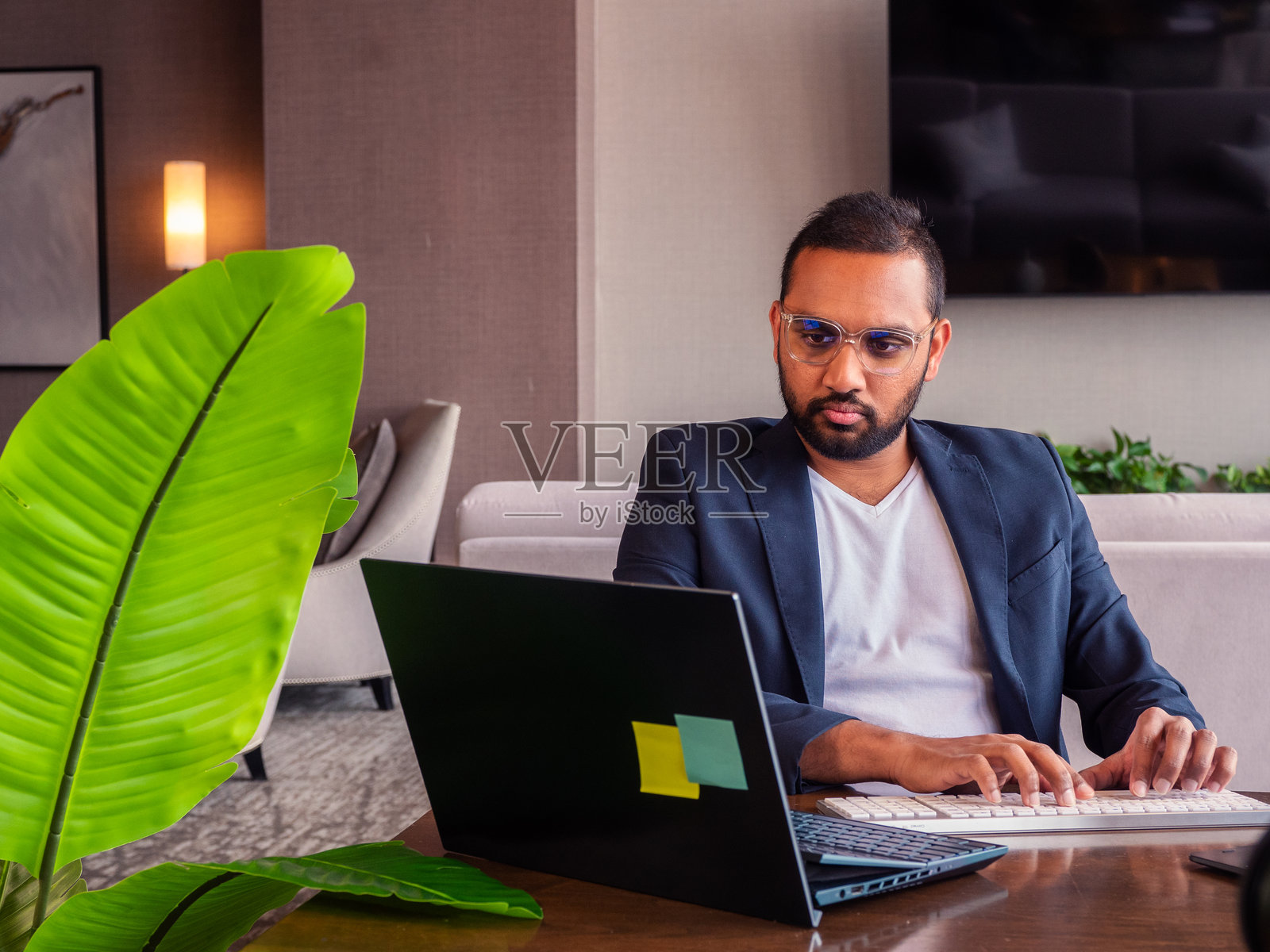 一位专业男士在现代办公室环境中用笔记本电脑工作照片摄影图片