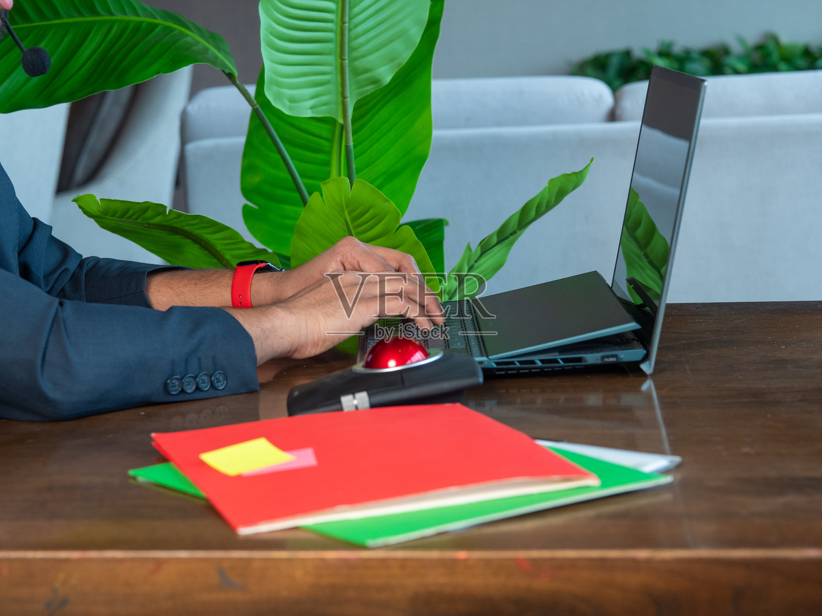 一个人在绿植环绕的工作区使用笔记本电脑打字照片摄影图片