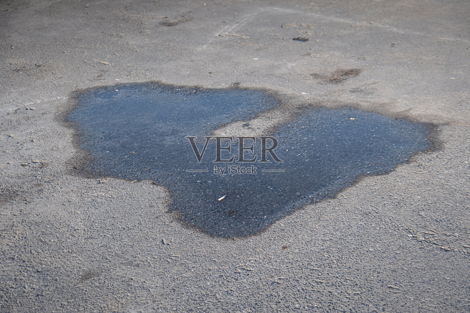 雨后和灌溉后，混凝土地板上的水坑。照片摄影图片