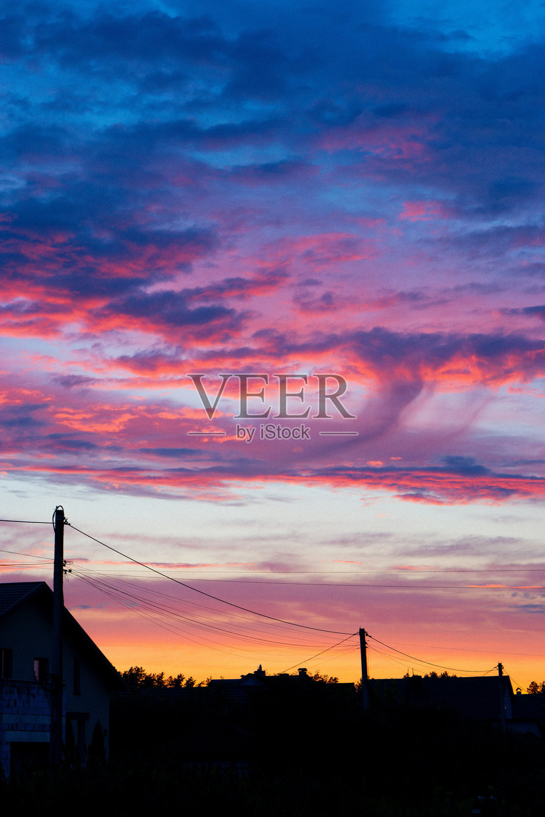 城市边缘建筑附近美丽的日落渐变，紫黄蓝红云彩照片摄影图片