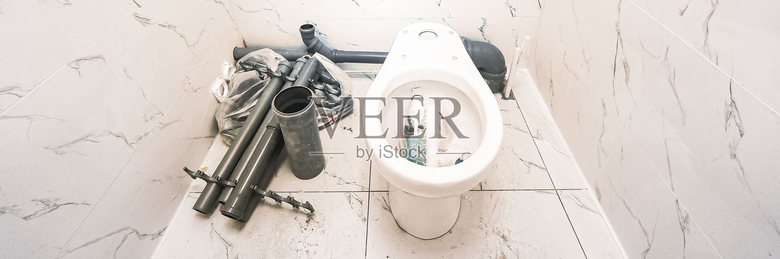 马桶堵塞，水流不止，用一块红布收集从排水沟褶皱处渗出的水。紧急管道维修照片摄影图片