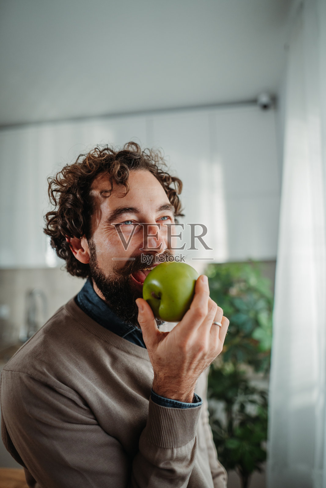 成熟的成年男子享受健康的青苹果零食照片摄影图片