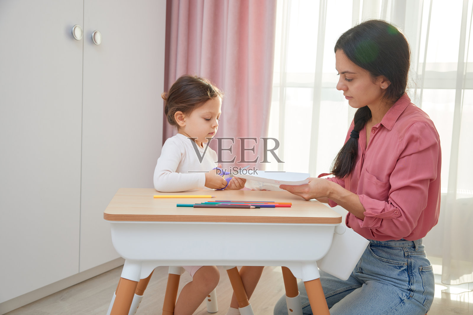 母亲和女儿用剪刀和纸学习手工制作照片摄影图片